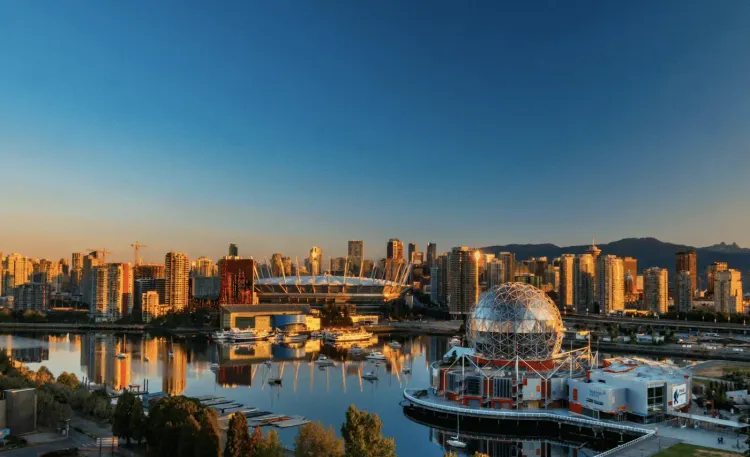 Golden hour panorama of Vancouver cityscape with BC Place stadium, Science World dome, and False Creek.