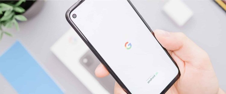 A hand holds a smartphone displaying the Google 'G' logo and 'Powered by android' text.