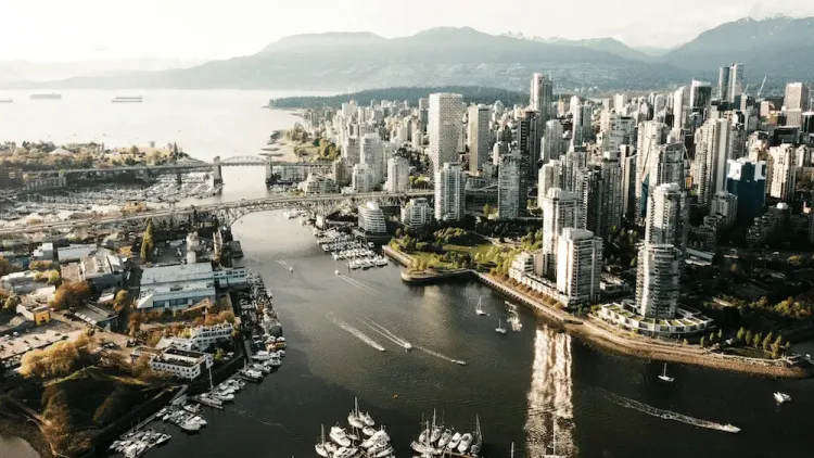 Aerial view of Vancouver's False Creek, downtown skyline, bridges, marinas, and North Shore mountains.